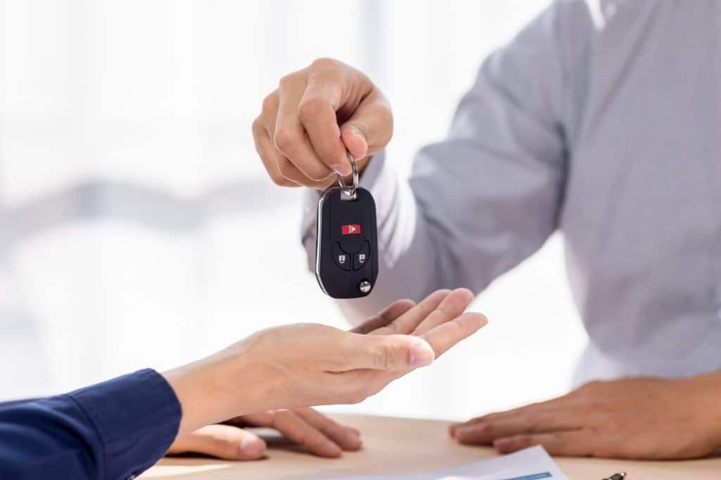 Car Insurance document or lease concept the car broker assisting his customer and explaining the